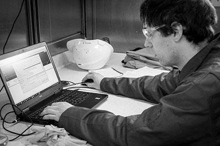 A man reading the data collected by acoustic tool on his laptop. 