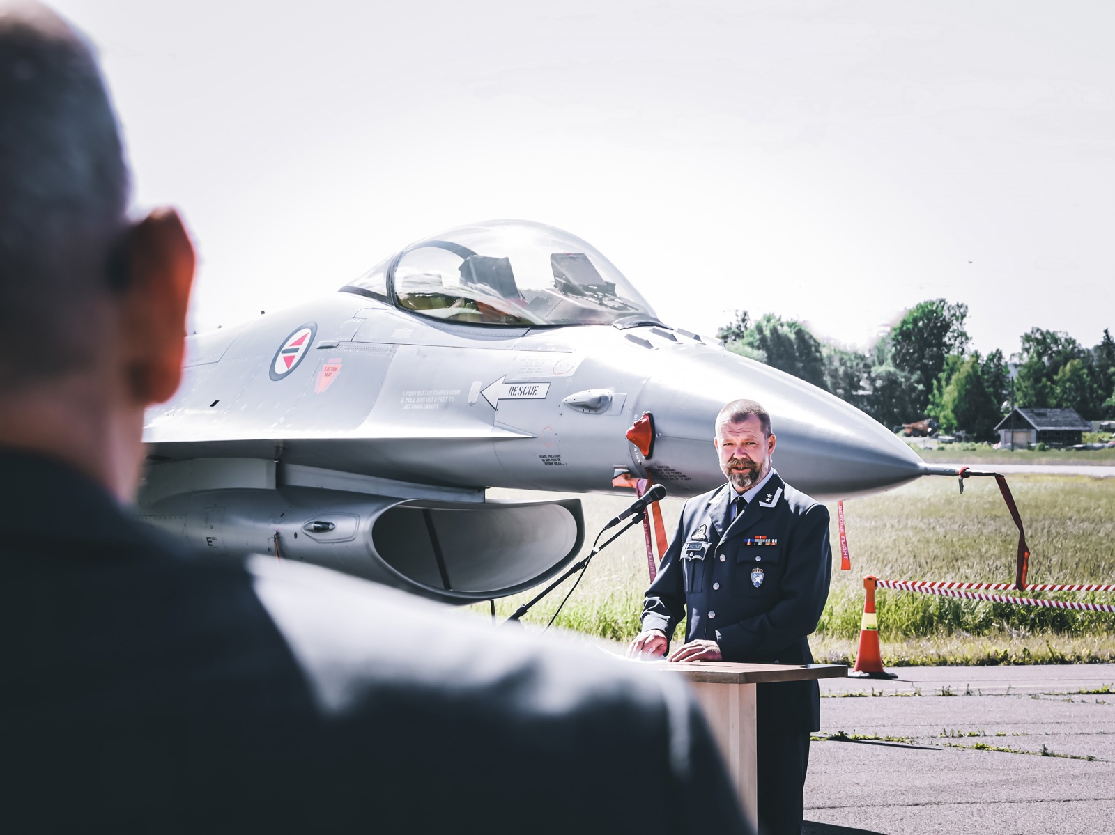 Officer hold a speech infront of a F-16