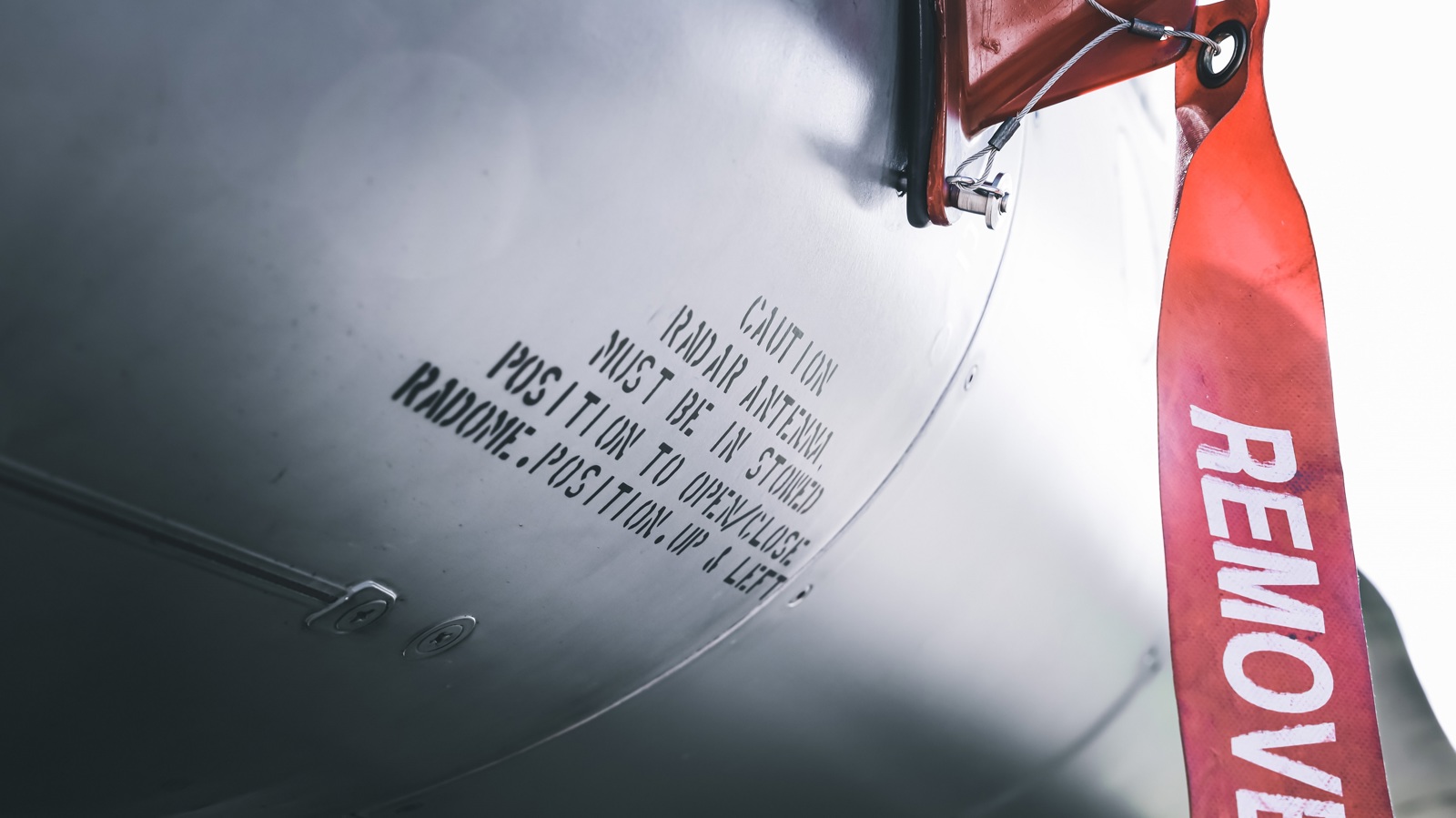 Detailed photo of F-16 fuselage with a "remove before flight" marker
