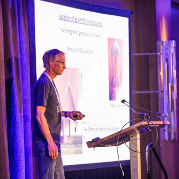 Man presenting on stage at a conference